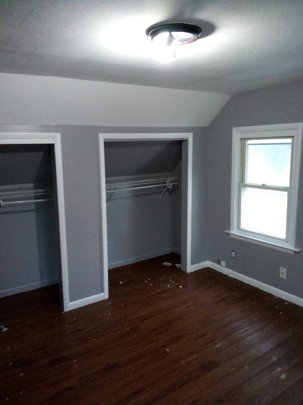 Same bedroom after: soft gray walls with white trim