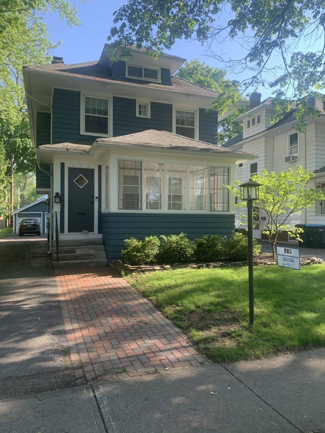 Green house on Leland Rd. with fresh paint and white trim